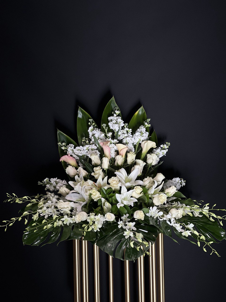 Pure Serenity Flower Arrangement :A serene blend of white lilies, orchids, stocks, and pink mini Calla lilies, symbolizing purity, elegance, and appreciation. Yonge Florist provide flower delivery locally and Great Toronto Area