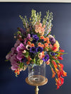 "Vivid Harmony Floral Arrangement: A burst of nature's colors featuring delphiniums, stocks, anemones, lisianthus, tulips, orchids, and mini calla lilies. Perfect for congratulating a new home, celebrating anniversaries, or sending birthday wishes. Expertly crafted by Yonge Florist for local and GTA flower delivery." front photo dark