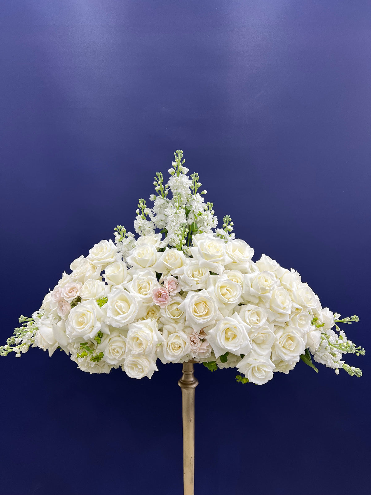 "Heavenly Embrace White Sympathy Arrangement by Yonge Florist - A serene blend of lilies, roses, spray roses, and hydrangeas, offering comfort and solace during difficult times. Reliable GTA flower delivery for funeral homes, chapels, churches, and cemeteries. Seasonal substitutions may occur to maintain style and color. Photography pedestal not included."
