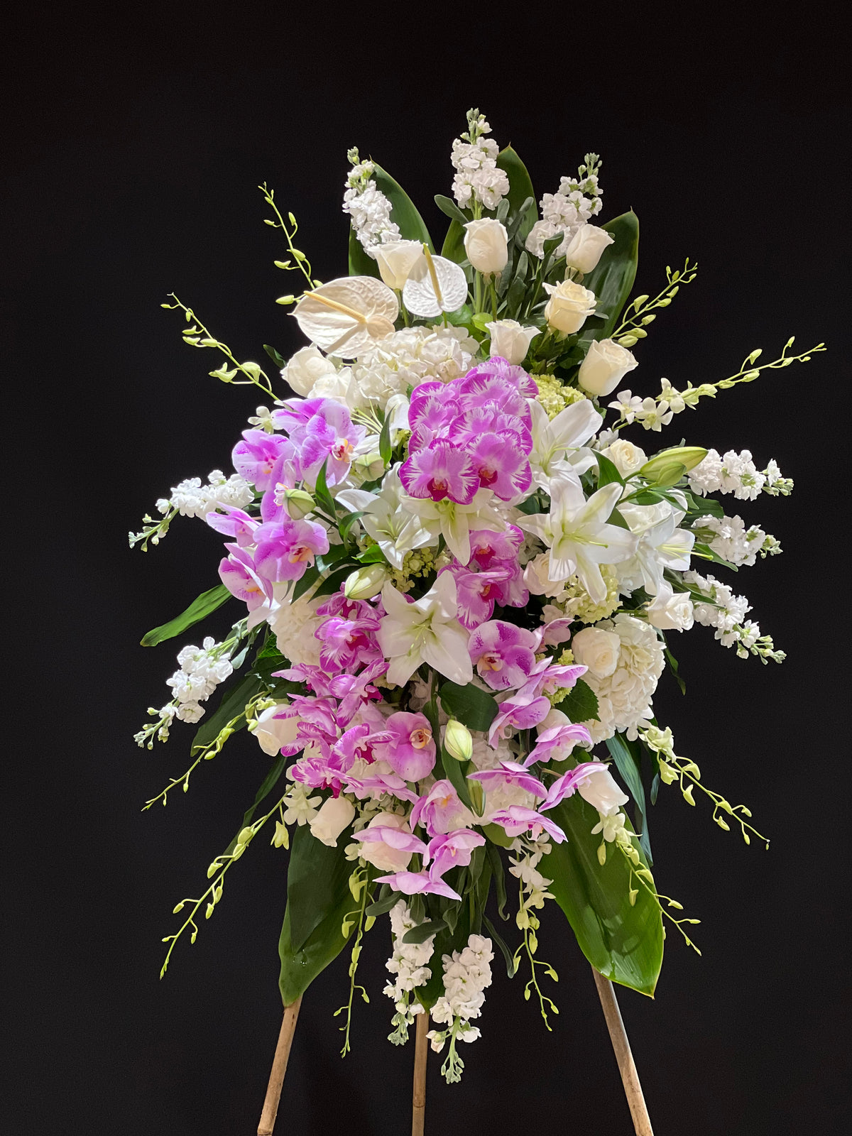 Floral standing spray with orchids, roses, anthuriums, lilies, and hydrangeas, including purple phalaenopsis orchids - Sympathy Tribute by Yonge Florist