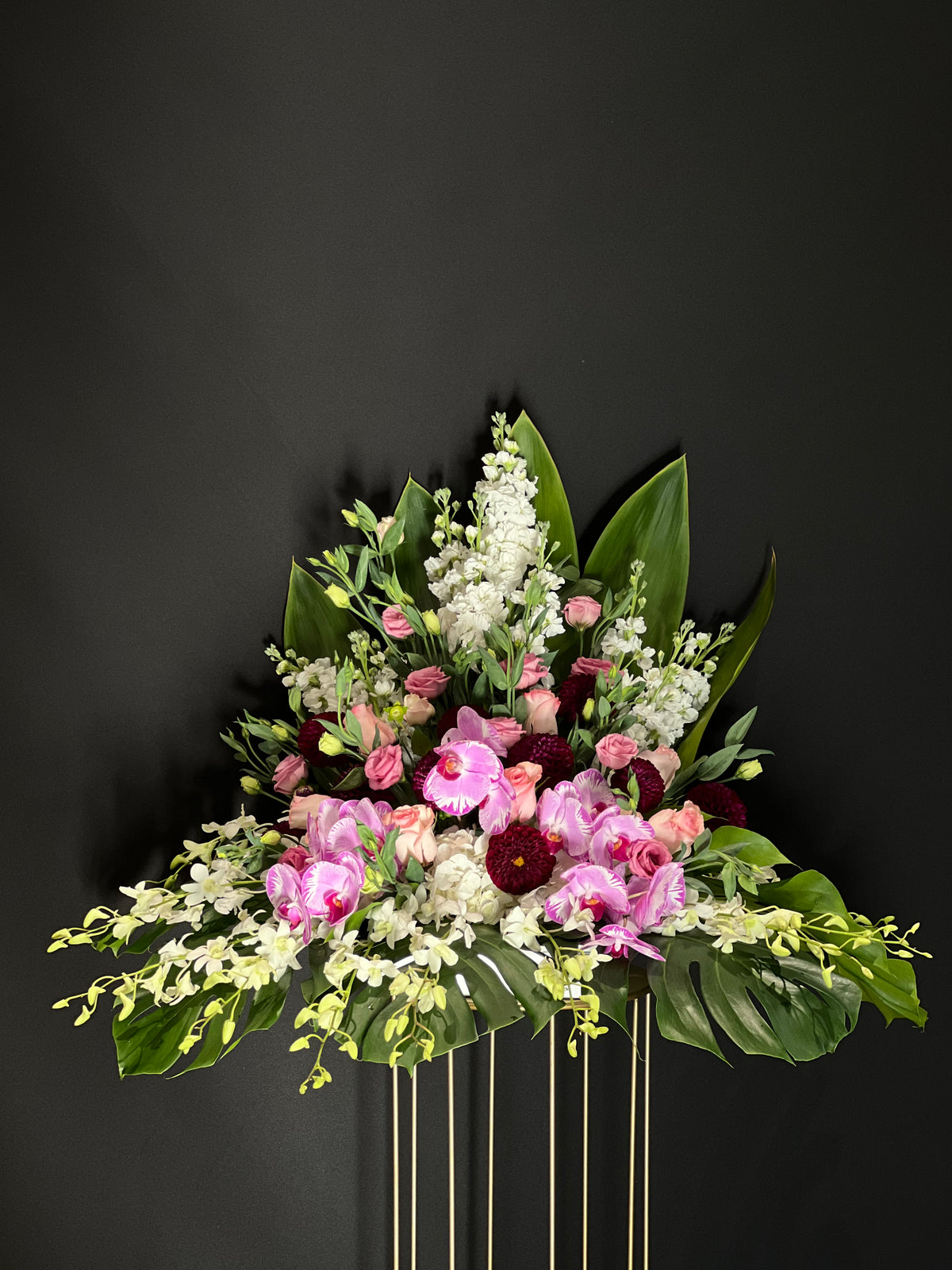 Burgundy Elegance Floral Arrangement - A harmonious blend of white and burgundy Stocks, Roses, Lisianthus, and regal Purple Phalaenopsis Orchids, perfect for expressing congratulations and positive feelings.