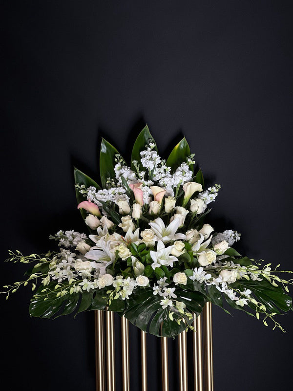 Pure Serenity Flower Arrangement :A serene blend of white lilies, orchids, stocks, and pink mini Calla lilies, symbolizing purity, elegance, and appreciation. Yonge Florist provide flower delivery locally and Great Toronto Area